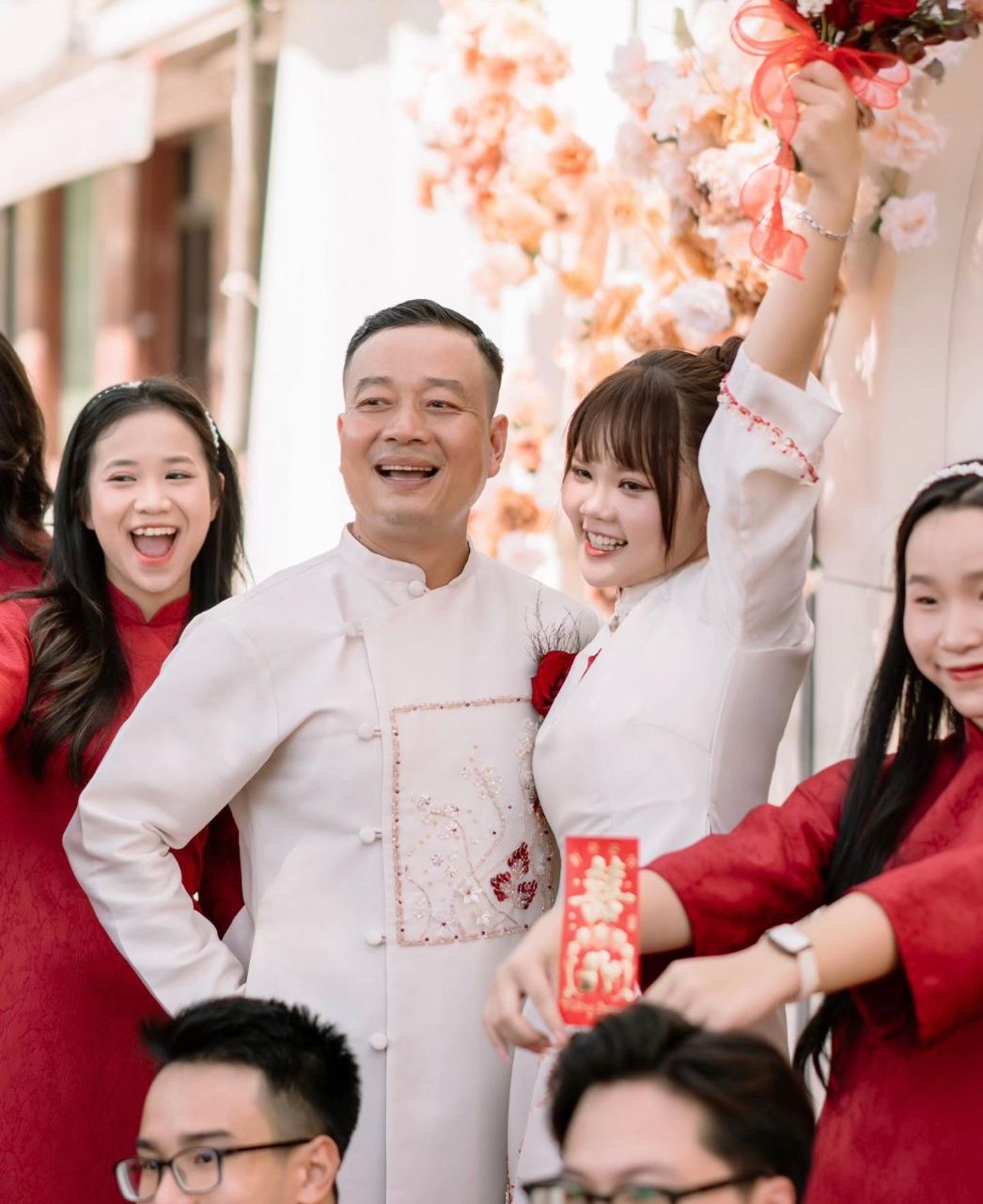 สามีภรรยาถ่ายรูปคู่กับเพื่อนและครอบครัวในพิธีหมั้น