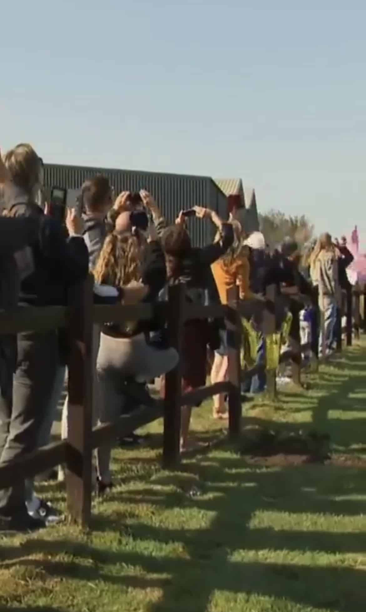 ประชาชนยืนเชียคุณยายที่กำลำลังกระโดร่ม