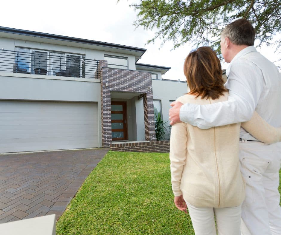 ชายหญิง 2 คนยืนดอบไหล่กันและมองไปยังบ้าน