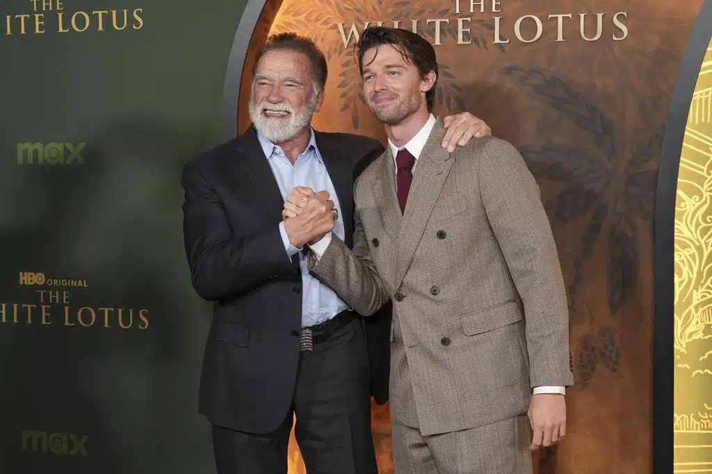 Arnold Schwarzenegger, left, and Patrick Schwarzenegger give the thumbs up at the season three premiere of "The White Lotus" on Monday, Feb. 10, 2025, at Paramount Theater in Los Angeles. 