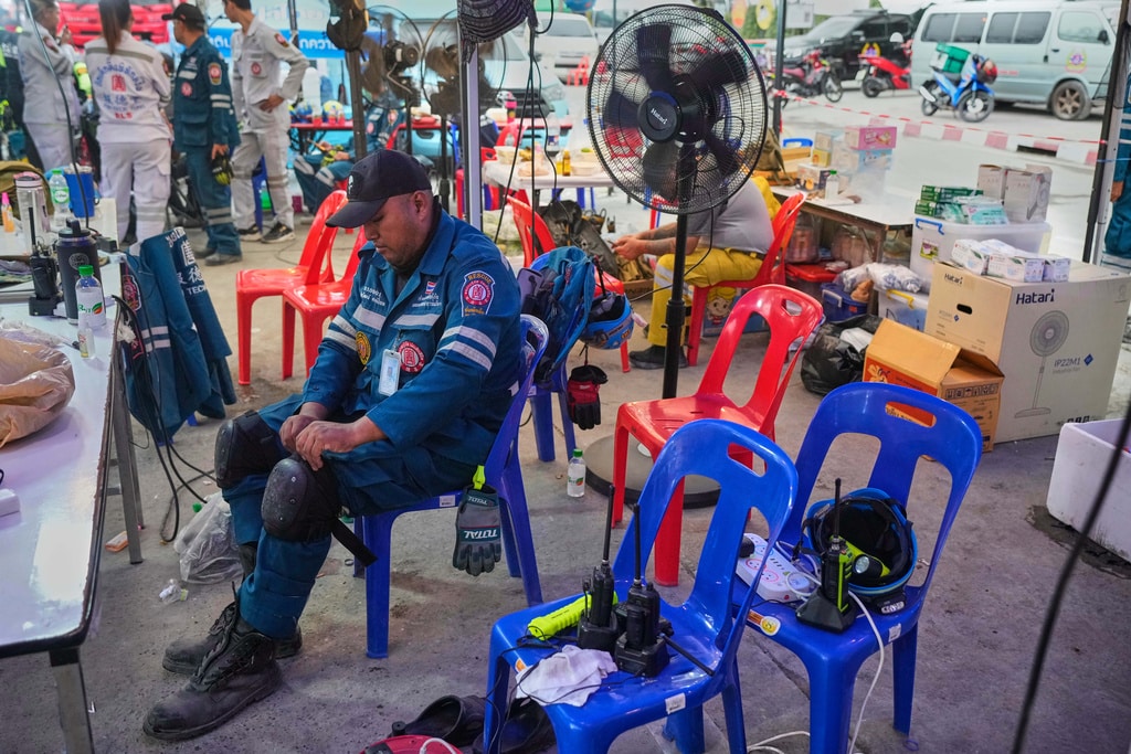 A rescuer gets ready for the day at the site of an under-construction high-rise building that collapsed after an earthquake in Bangkok, Thailand, Monday, March, 31, 2025.