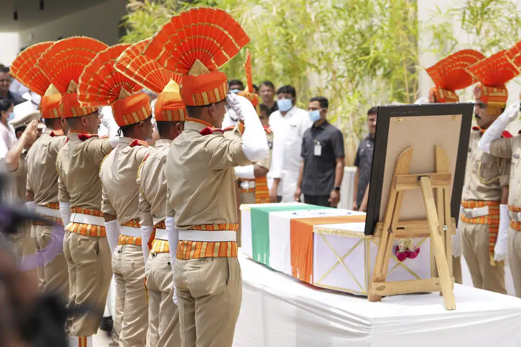 Policemen salute to the body of former Chief Minister of Gujarat Vijay Rupani, victim of Thursday's Air India plane crash, at a hospital in Ahmedabad, India, Monday, June 16, 2025.