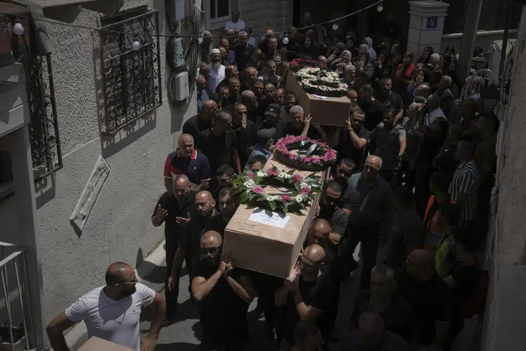 Mourners carry the caskets of four members of the Khatib family, Palestinian citizens of Israel killed in an Iranian missile strike on Tamra, Israel, during their funeral, on Tuesday, June 17, 2025.