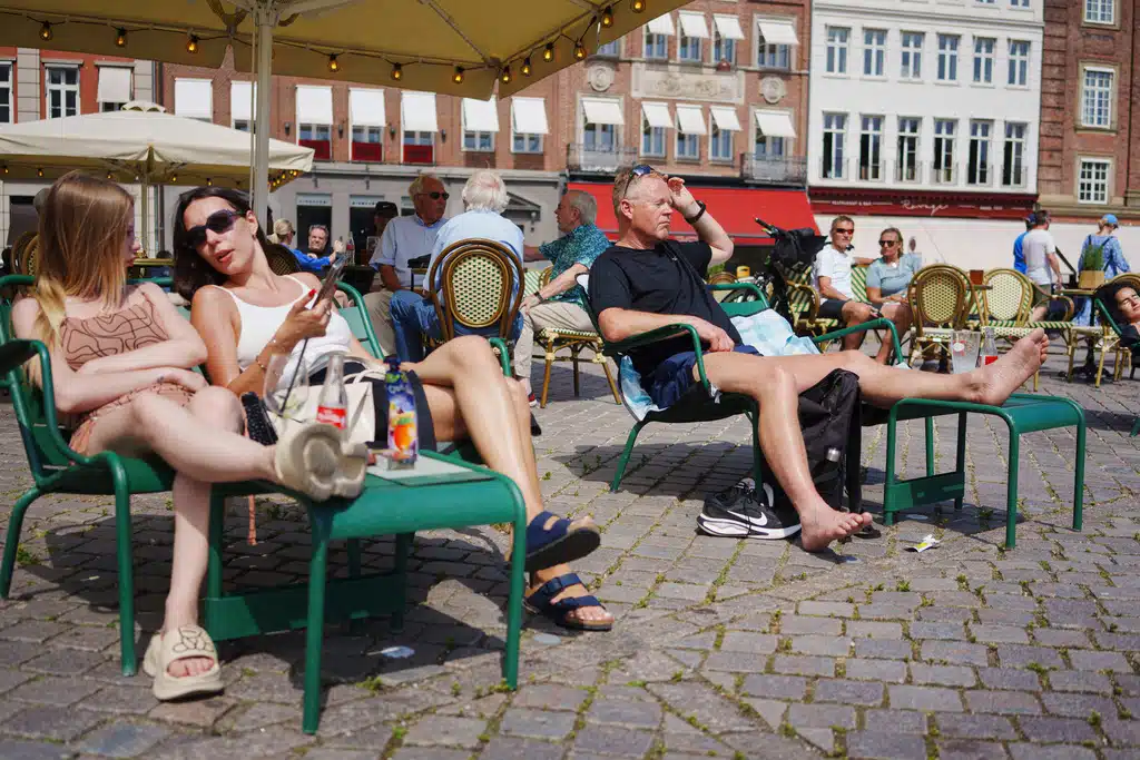 People sit in the sun during hot and sunny weather in Copenhagen, Wednesday, July 2, 2025.