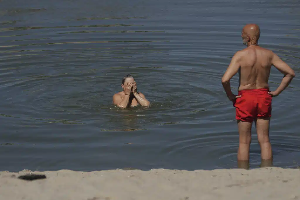 People cool off during a hot summer day on the sandbank on Danube river in Belgrade, Serbia, Thursday, July 3, 2025.