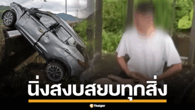 ภาพชายชาวไต้หวันในชุดสีเทานั่งสมาธิอยู่ริมถนนทางด่วน