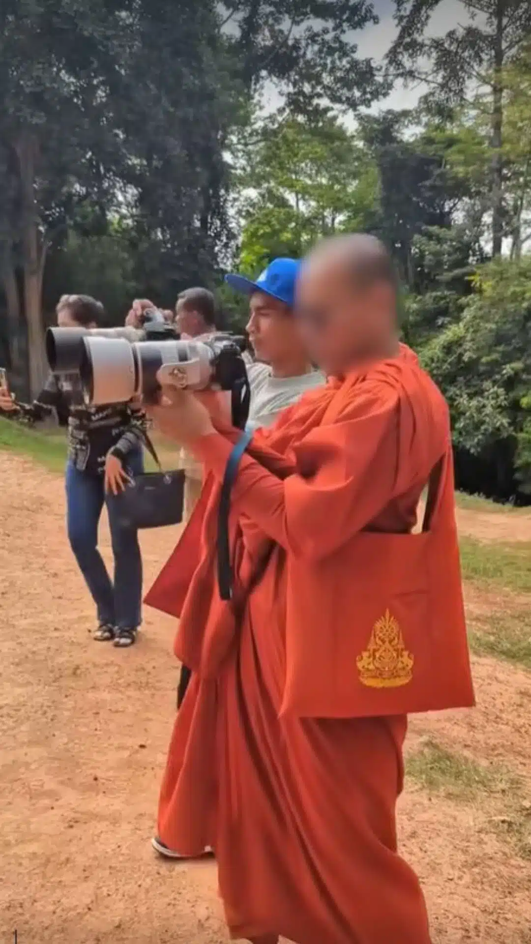 พระสงฆ์ชาวกัมพูชากำลังถือกล้องถ่ายภาพใกล้กับทหารไทย