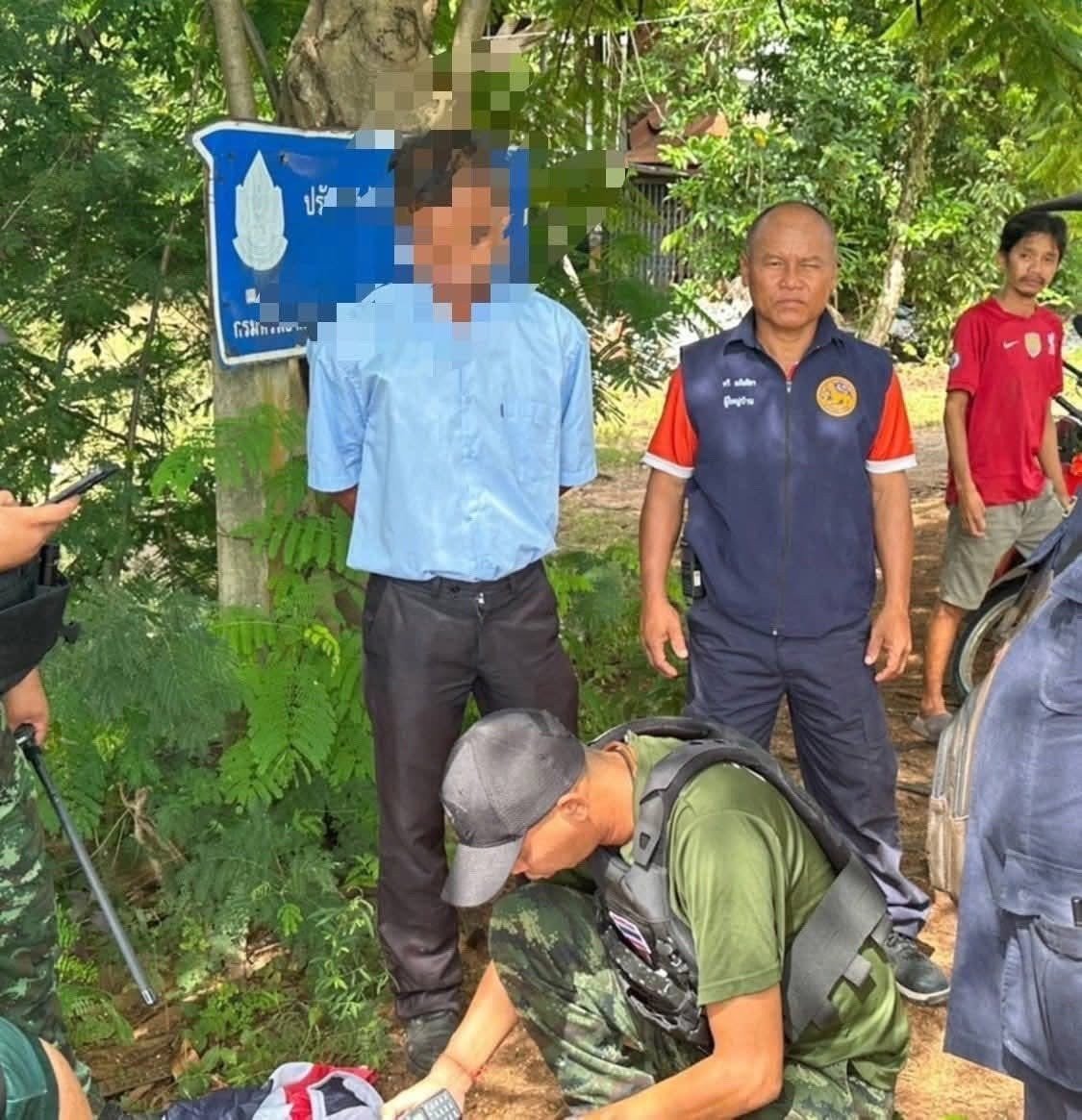 เจ้าหน้าที่ทหารและชาวบ้านกำลังควบคุมตัวชายต้องสงสัย