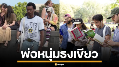 ชายหนุ่มแต่งตัวตามสไตล์ Performative Male ถือหนังสือเกี่ยวกับพลังหญิง