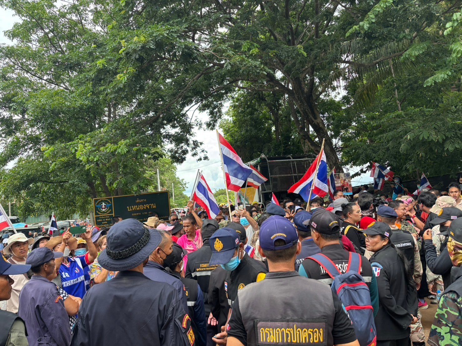 กลุ่มคนไทยจำนวนมากกำลังโบกธงชาติไทยที่บ้านหนองจาน