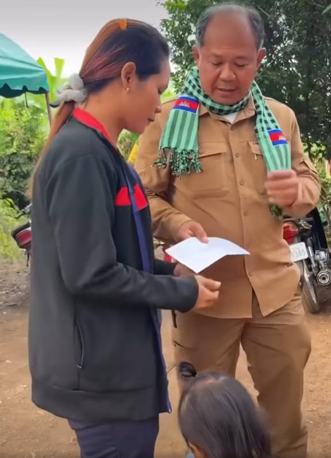 นายอุม เรียตรีย์ ผู้ว่าฯ บันทายมีชัย กำลังมอบเงินรางวัลให้หญิงชาวกัมพูชา