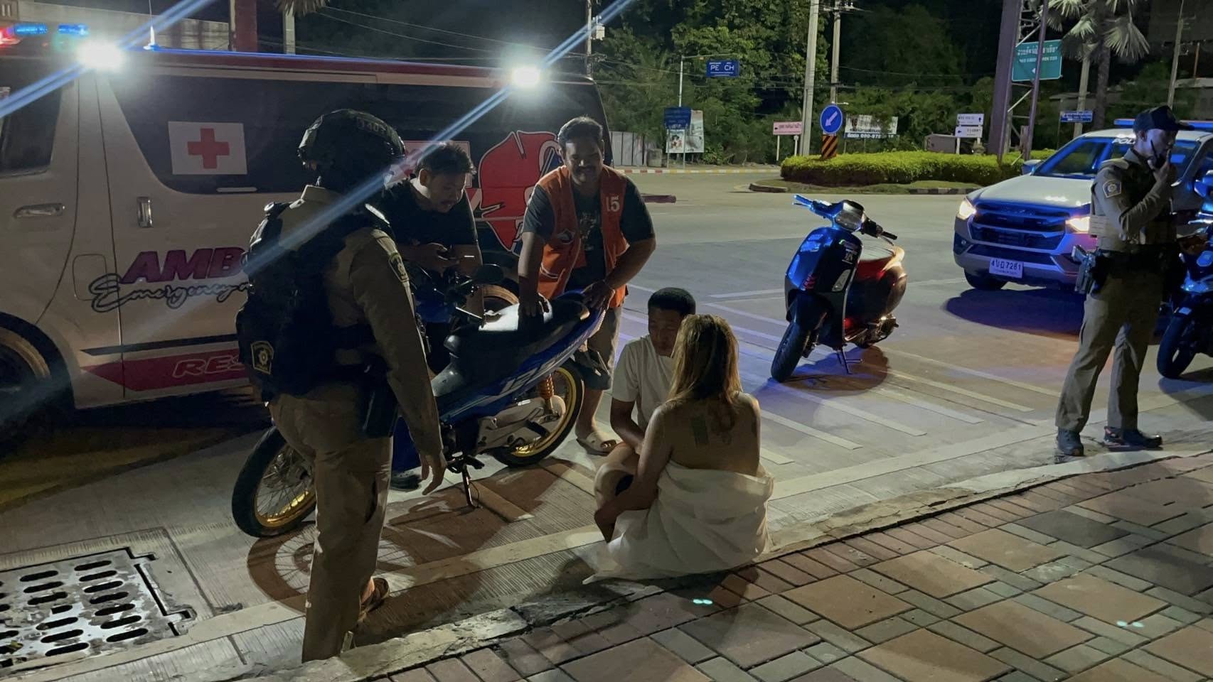 เจ้าหน้าที่กู้ภัยกำลังพูดคุยกับหญิงสาวที่นั่งอยู่ริมถนนสุขุมวิท