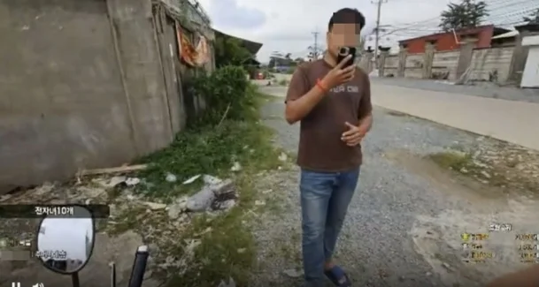 ชายชาวกัมพูชาที่กำลังใช้โทรศัพท์มือถือถ่ายรูปบีเจ A
