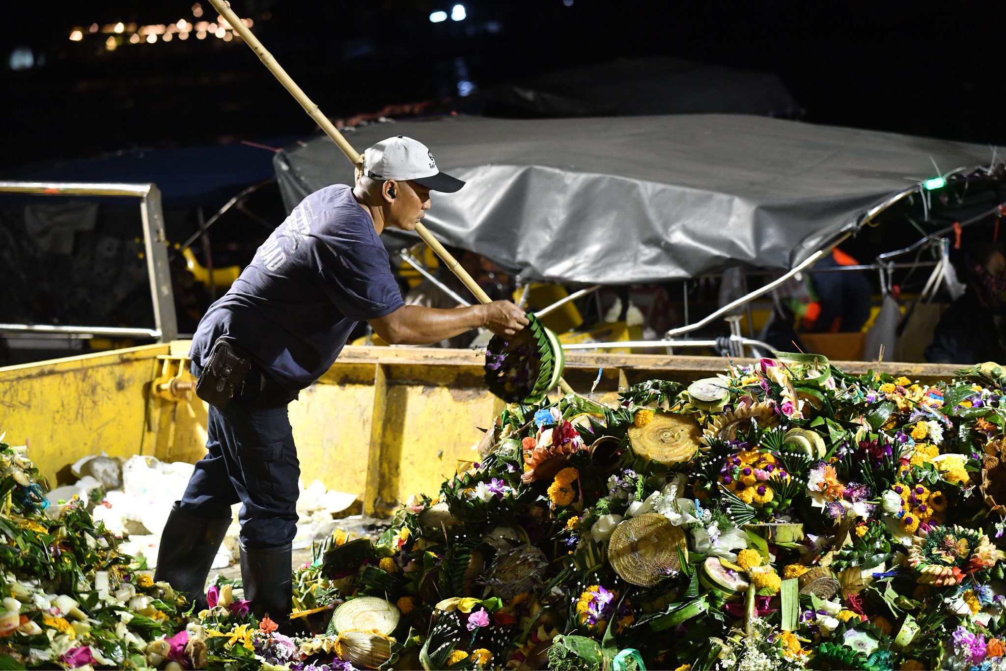 เจ้าหน้าที่ กทม. กำลังตักกระทงที่ทำจากวัสดุธรรมชาติออกจากแม่น้ำเจ้าพระยา