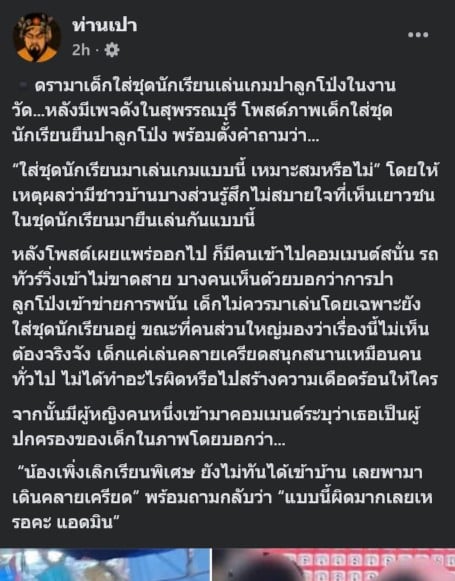 เด็กในชุดนักเรียนกำลังปาลูกโป่งในงานวัดที่สุพรรณบุรี