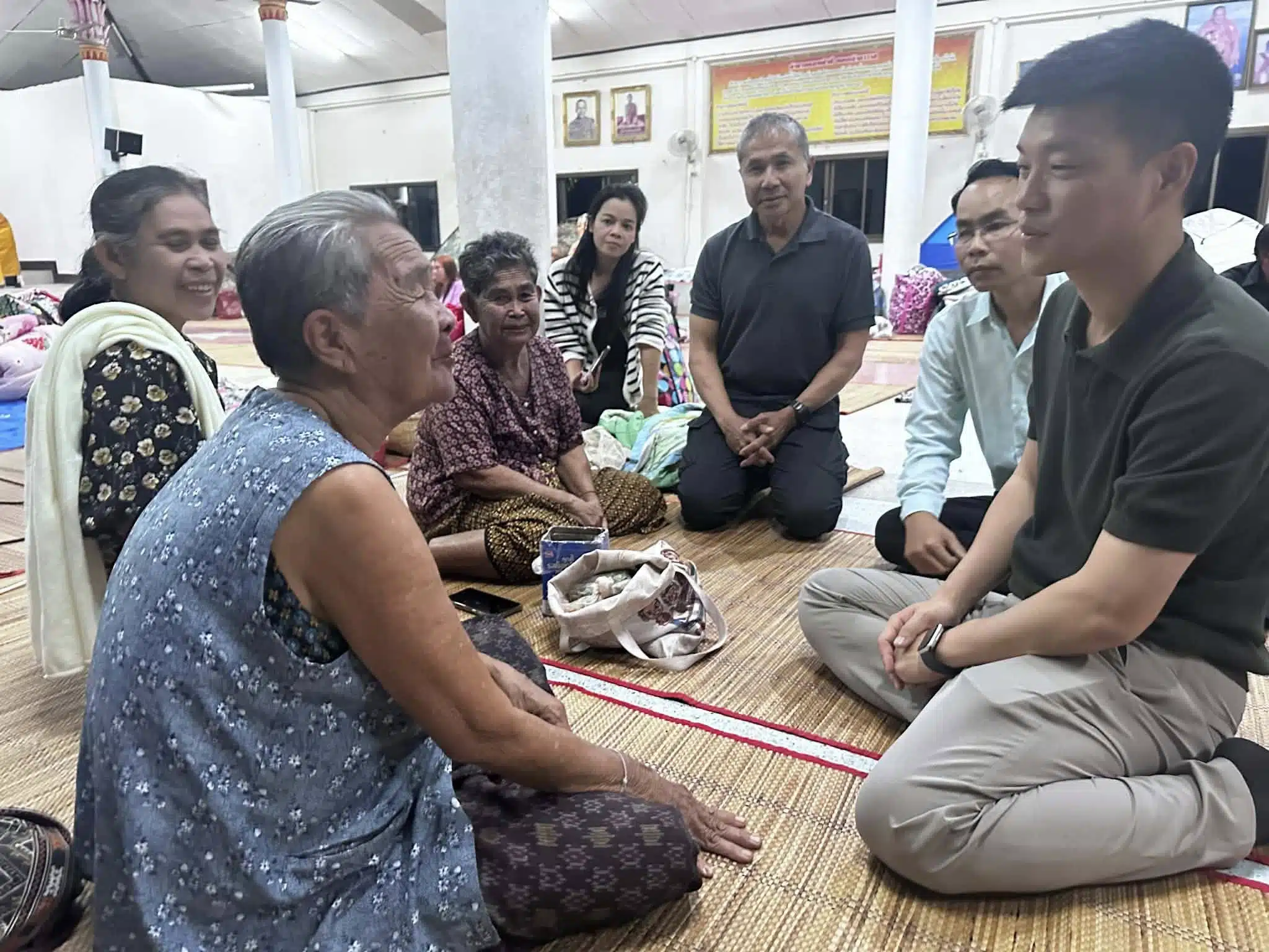 ณัฐพงษ์ เรืองปัญญาวุฒิ นั่งพูดคุยกับผู้สูงอายุในศูนย์อพยพอย่างเป็นกันเอง