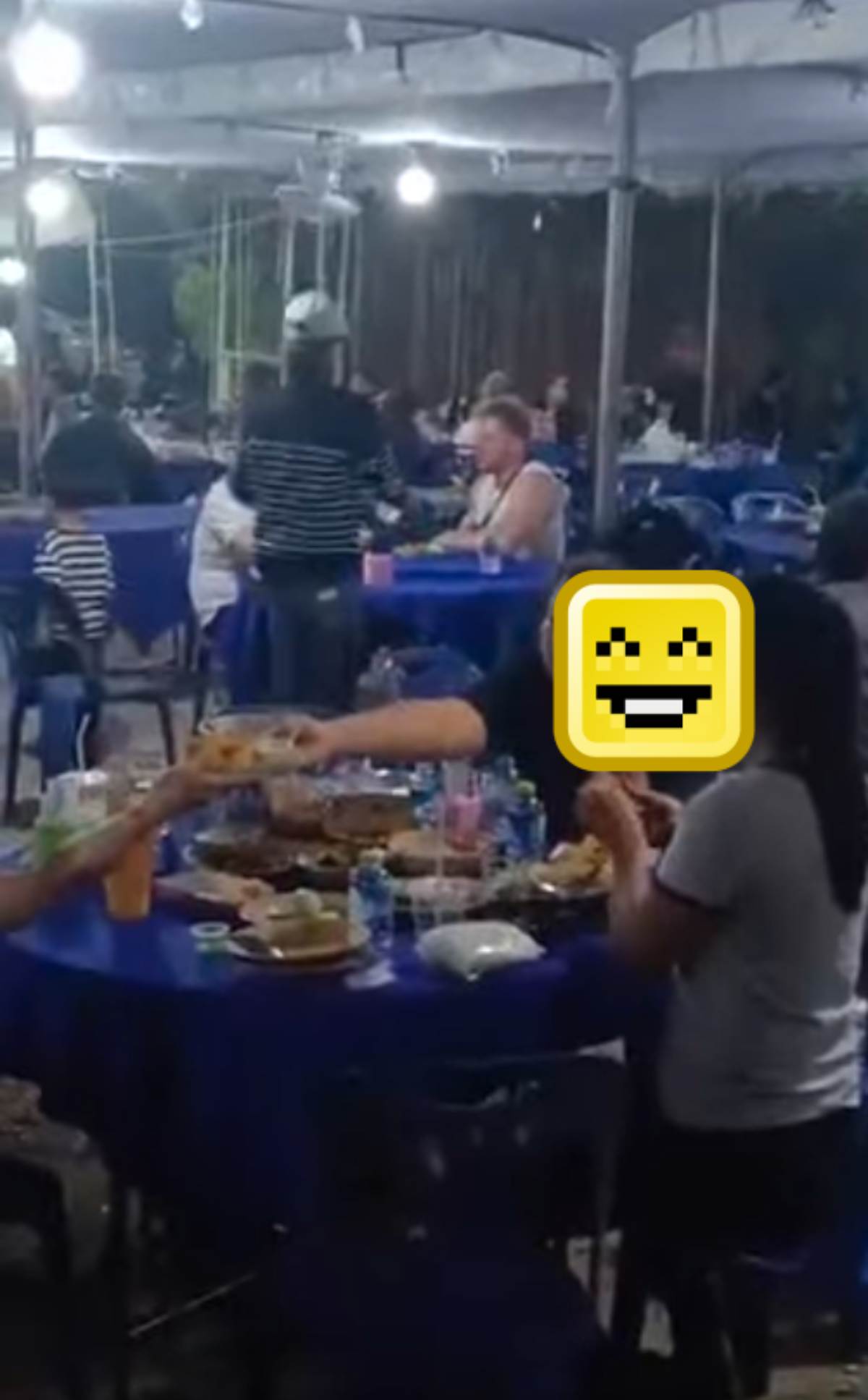 คนในงานศพขณะเดินถือถาดอาหารมาให้แขกฝรั่ง 2 ราย