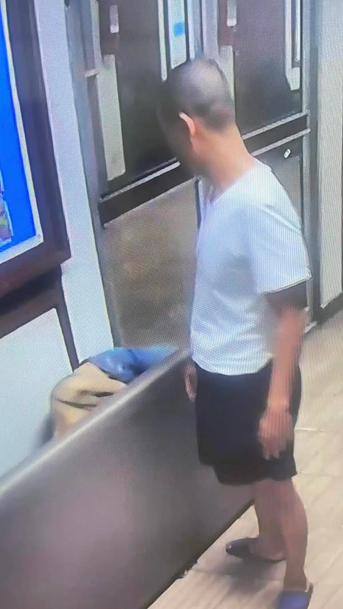 เจ้าหน้าที่ตำรวจในชุดนอกเครื่องแบบบนโรงพักที่เกิดเหตุ ยืนดูหญิงสาวที่รถล้มนอนไม่ได้สติ