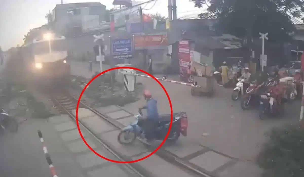 ผู้ขับขี่รถจักรยานยนต์ข้ามรั้วกั้นทางรถไฟขณะกำลังคุยโทรศัพท์ในกรุงฮานอยผู้ขับขี่รถจักรยานยนต์ข้ามรั้วกั้นทางรถไฟขณะกำลังคุยโทรศัพท์ในกรุงฮานอย