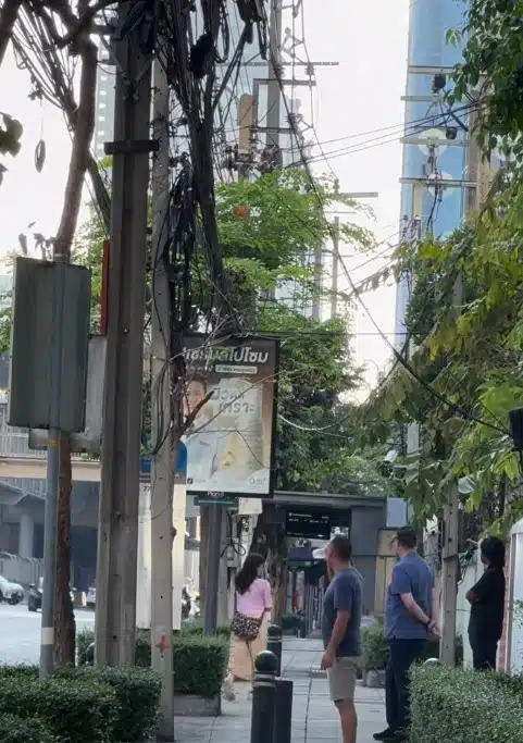 ชายชาวต่างชาติยืนคุมเชิงป้องกันชายสวมเสื้อสีดำบนถนนสาทร