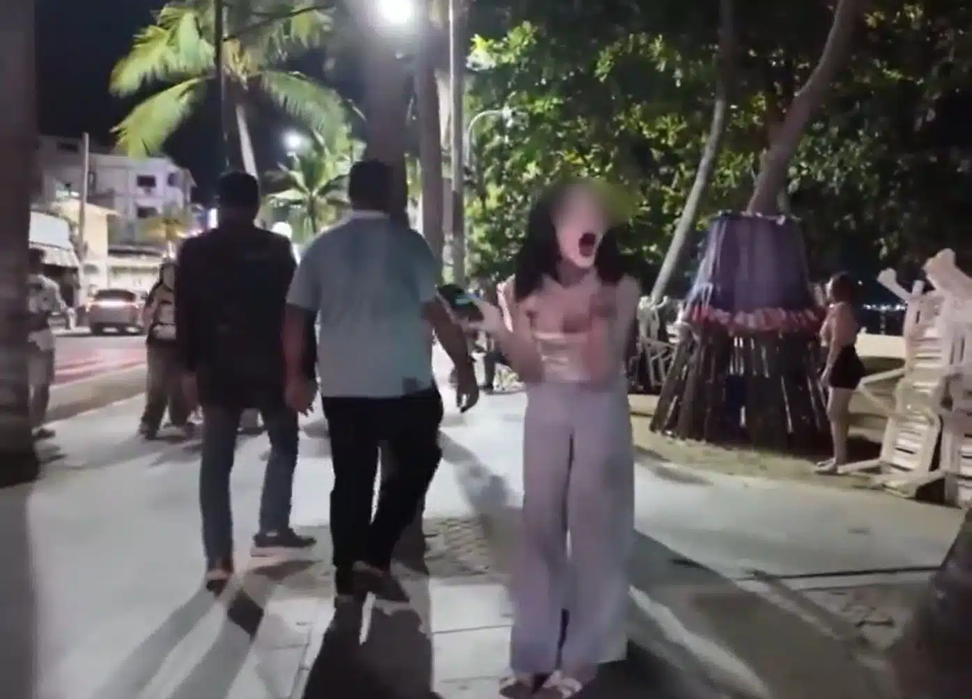 หญิงไทยแสดงอาการคล้ายจะอาเจียนขณะชายอินเดียเดินผ่าน