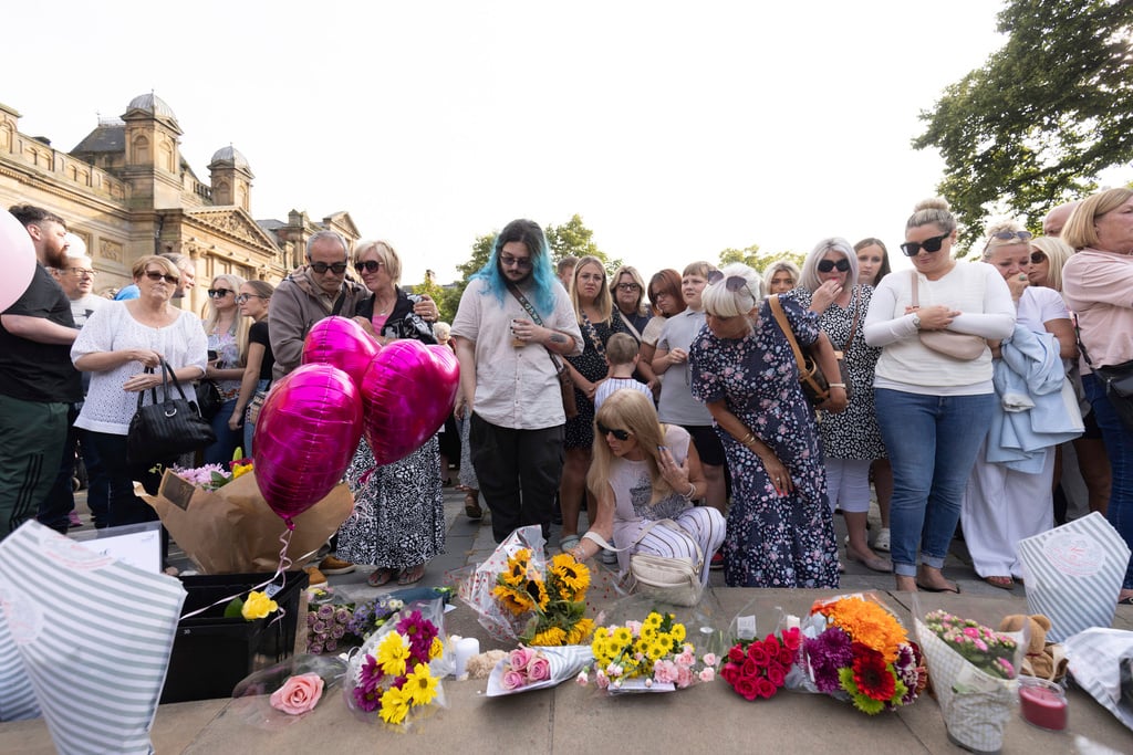 Members of the public take part in a vigil near the scene in Hart Street, in Southport, England, Tuesday, July 30, 2024, where three children died and eight were injured in a knife attack during a Taylor Swift event at a dance school on Monday. 