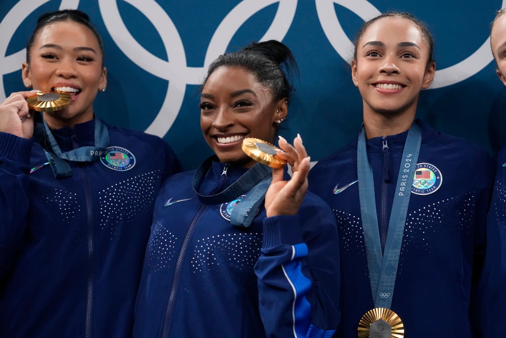 From left to right, Suni Lee, Simone Biles, Hezly Rivera celebrate after winning the gold medal during the women's artistic gymnastics team finals round at Bercy Arena at the 2024 Summer Olympics, Tuesday, July 30, 2024, in Paris, France. 
