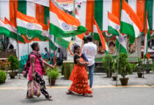 Commuters walk on a street decorated with Indian national flags during the country's Independence Day celebrations in Kolkata, India, Thursday, Aug. 15, 2024. (AP Photo/Bikas Das)