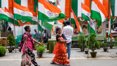 Commuters walk on a street decorated with Indian national flags during the country's Independence Day celebrations in Kolkata, India, Thursday, Aug. 15, 2024. (AP Photo/Bikas Das)