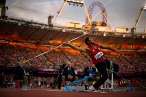 In light from the setting sun, Tunisia's Mohamed Ali Krid makes a throw in the men's javelin F34 category event during the athletics competition at the 2012 Paralympics, Sept. 1, 2012, in London. (AP Photo/Matt Dunham).