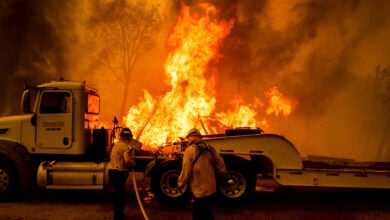 Firefighters spray water as the Park Fire