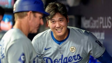 Los Angeles Dodgers two-way player Shohei Ohtani laughs with teammates in the dugout in the ninth inning of a baseball game against the Atlanta Braves, Sunday, Sept. 15, 2024, in Atlanta. (AP Photo/Jason Allen).