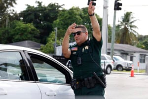 A police officer directs traffic near Trump International Golf Club after the apparent assassination attempt of Republican presidential nominee former President Donald Trump in West Palm Beach, Fla., Sunday, Sept. 15, 2024. (AP Photo/Terry Renna).