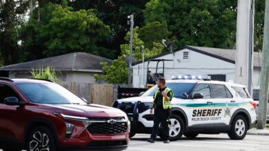 A police officer directs traffic near Trump International Golf Club after the apparent assassination attempt of Republican presidential nominee former President Donald Trump in West Palm Beach, Fla., Sunday, Sept. 15, 2024. (AP Photo/Terry Renna).