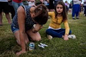 Brandy Rickaba and her daughter Emilie pray during a candlelight vigil for the slain students and teachers at Apalachee High School, Wednesday, Sept. 4, 2024, in Winder, Ga. (AP Photo/Mike Stewart).