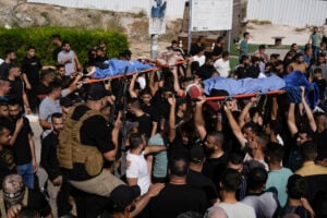 Mourners, some armed, carry the bodies of five Palestinians during their funeral in Tubas, West Bank, Thursday, Sept. 5, 2024. Palestinian health officials say Israeli strikes in the occupied West Bank killed five people. Israel has been carrying out large-scale raids in the territory over the past week that it says are aimed at dismantling militant groups and preventing attacks. (AP Photo/Majdi Mohammed).