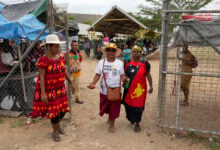 A woman, center, wears a shirt with a photo of Pope Francis at a market ahead of his visit to Port Moresby, Papua New Guinea, Friday, Sept. 6, 2024. (AP Photo/Mark Baker).