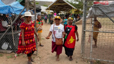 A woman, center, wears a shirt with a photo of Pope Francis at a market ahead of his visit to Port Moresby, Papua New Guinea, Friday, Sept. 6, 2024. (AP Photo/Mark Baker).