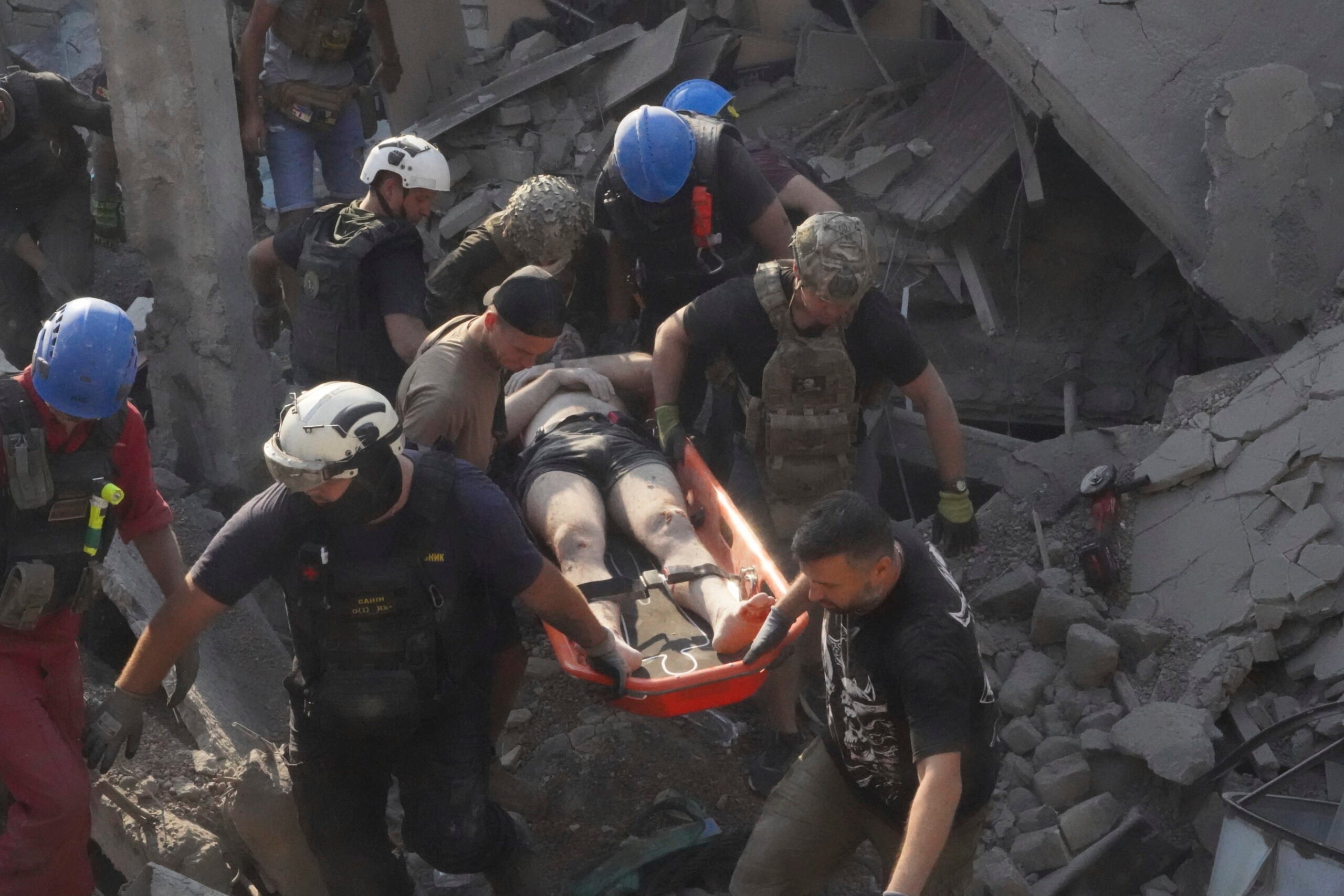 Rescuers carry a wounded man after Russian missile attack on the city palace of sports in Kharkiv, Ukraine, Sunday, Sept. 1, 2024. Over 40 civilians were injured in Sunday's missile attack. (AP Photo/Andrii Marienko).