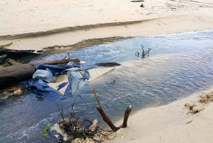 Rank canal water overflows onto Phuket beach