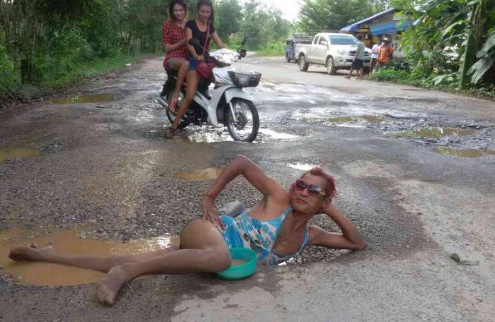 Man ‘bathes’ in pothole to push road repairs