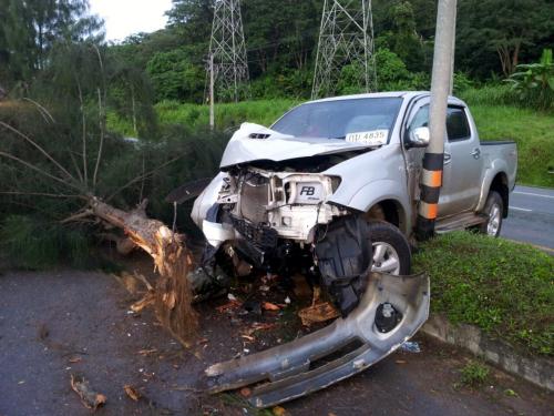 Phuket policeman escapes injury after slippery road slams pickup into tree