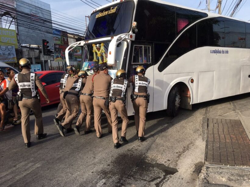 Phuket Police push a broken down bus out of peak hour traffic