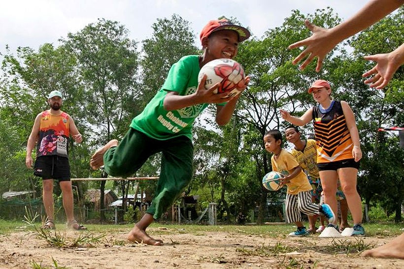 Burmese kids dodging cows and cow dung to play rugby