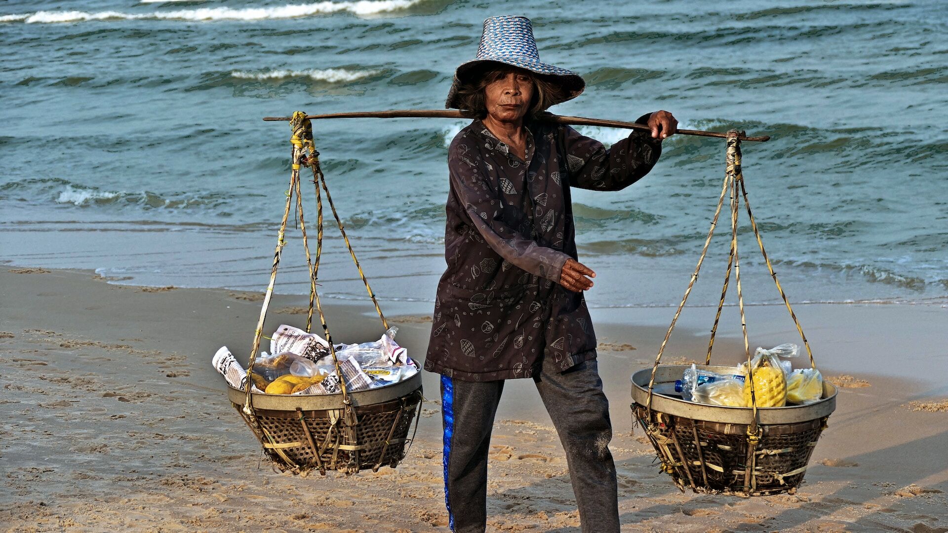 PHOTO: Woman carrying basket in Hua Hin by zibik via Unsplash
