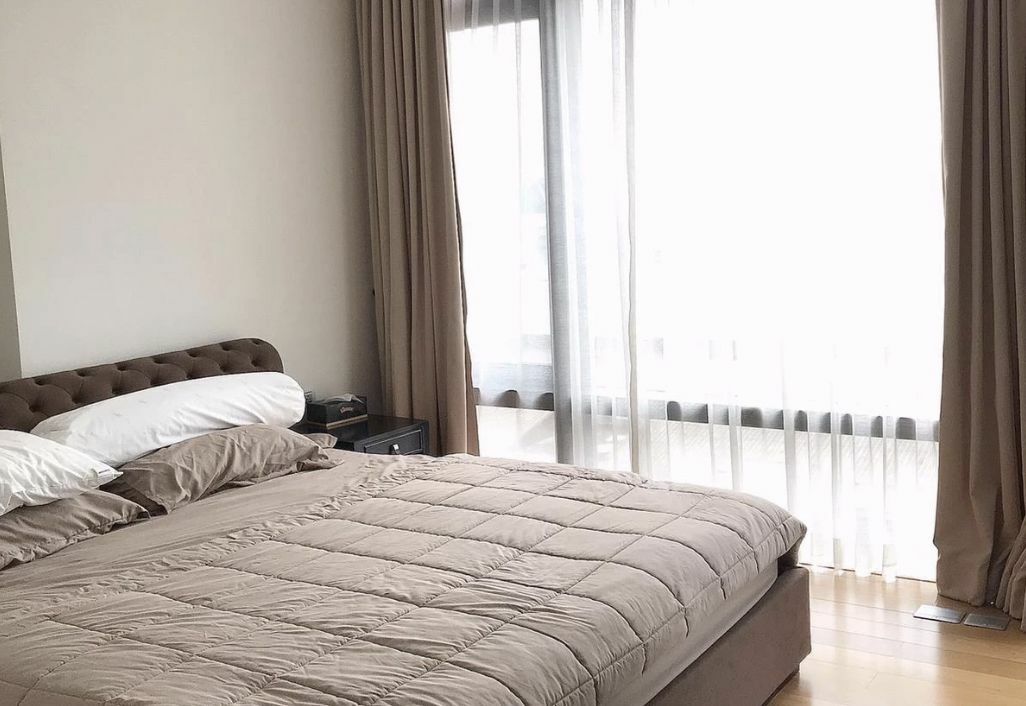 A picture of a bedroom in a condo for sale in Bangkok. Everything is in brown.