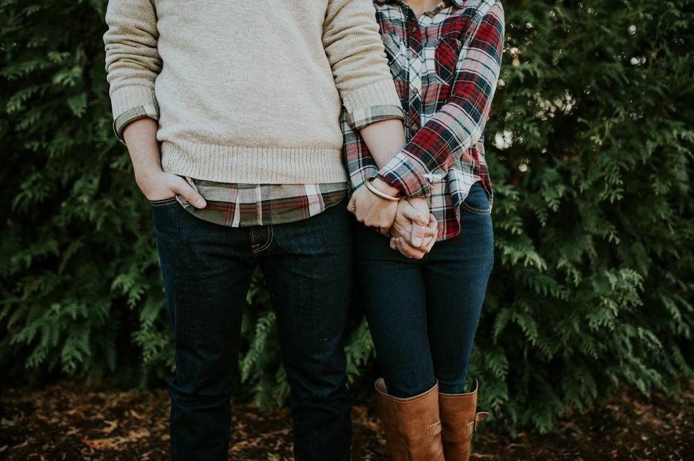 A couple hold their hand