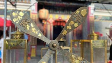 Hong Kong temple tells Thai tourists to stop sticking gold leaf on prayer wheel
