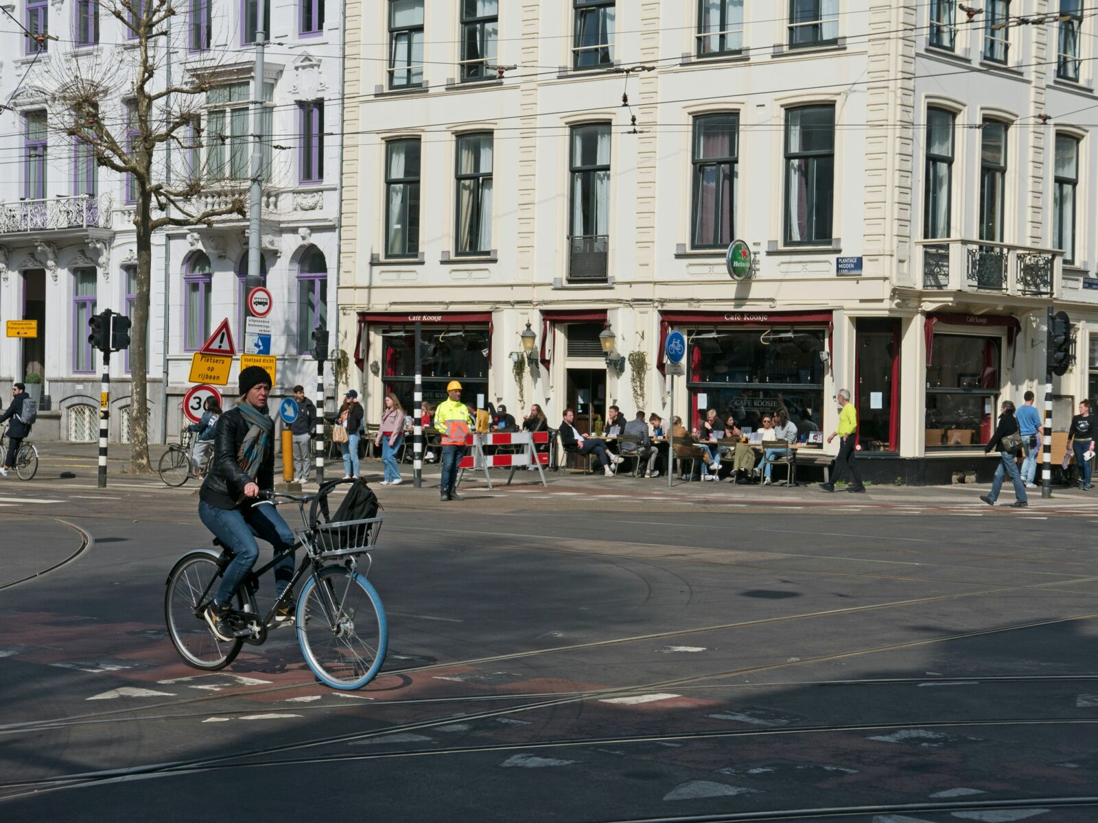 Woman is biking over the street crossing Plantage Middenlaan.