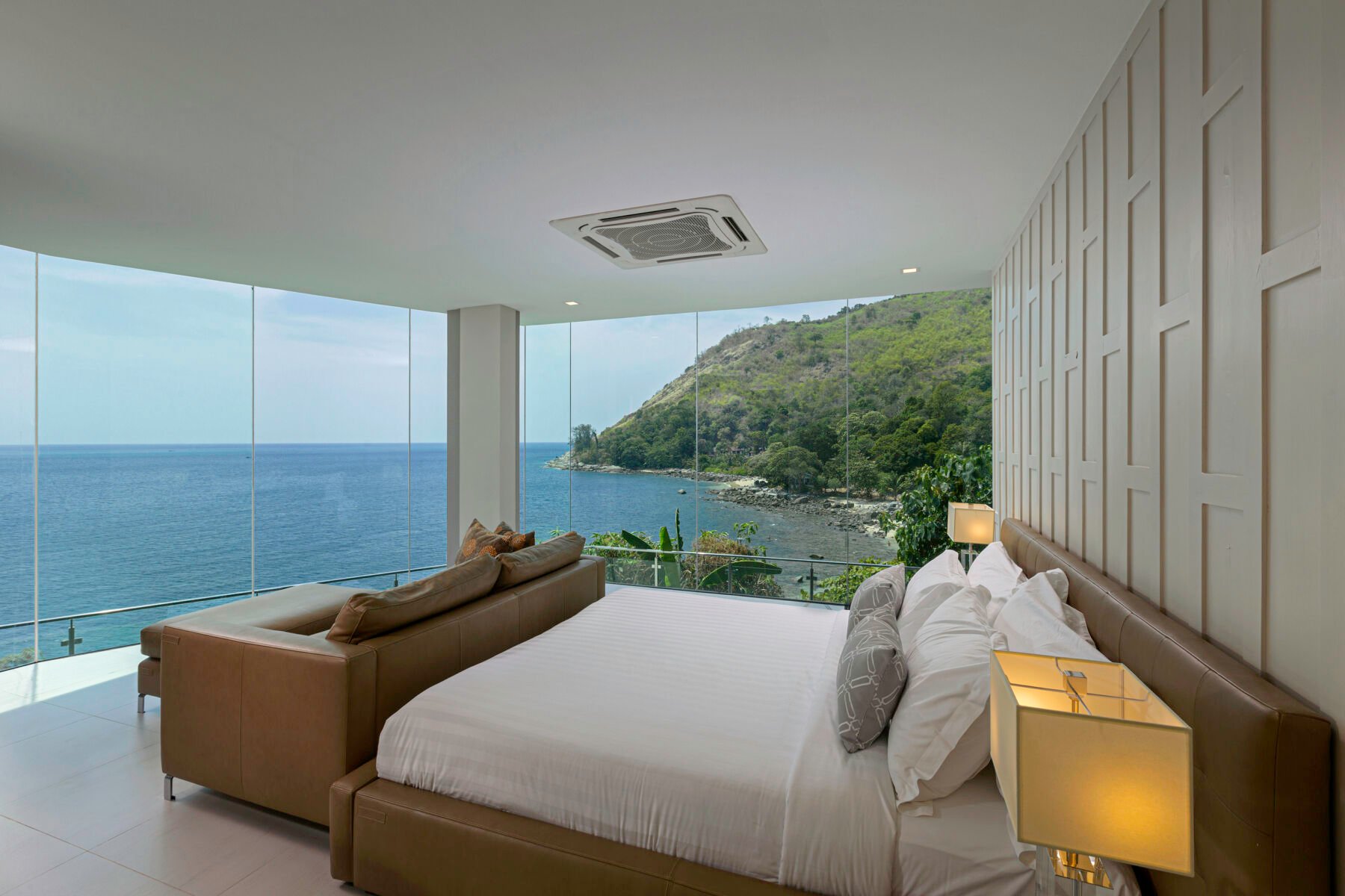 A big bedroom with glass walls overlooking the ocean - a luxury villa in Phuket, Thailand